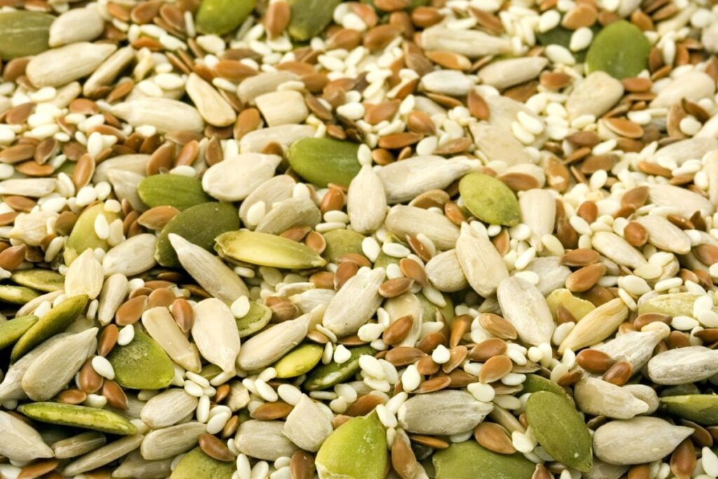 Selecionamos uma imagem simbólica para representar o ciclo das sementes e poder escrever sobre o equilíbrio hormonal de forma natural. Na imagem, aparece de perto sementes de abóbora, linhaça, girassol e gergelim.