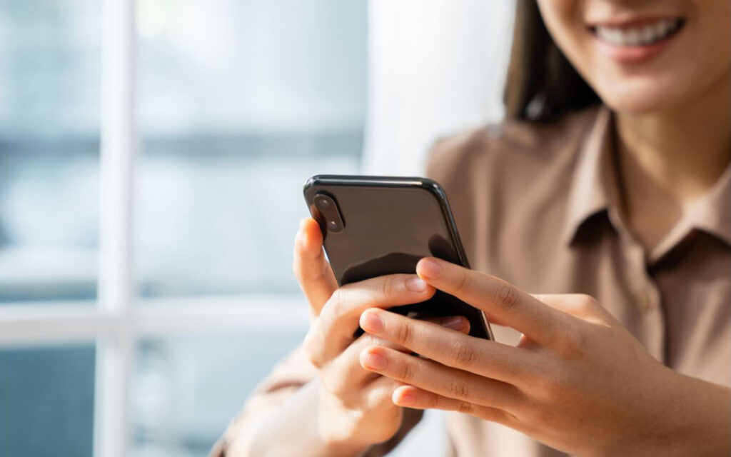 Selecionamos uma imagem simbólica para representar o nosso canal de comunicação "Contato". Na imagem, uma mulher digitando no celular.